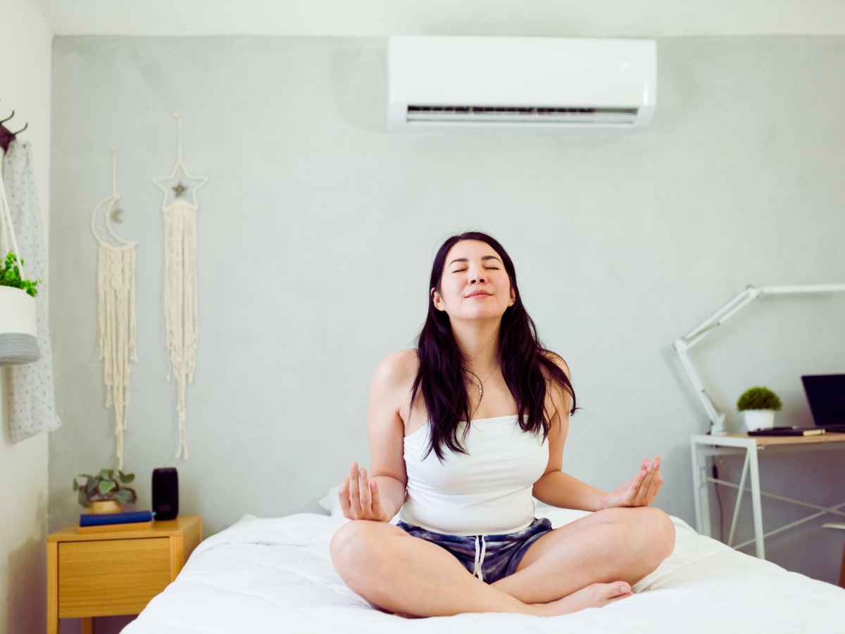 Woman enjoying her mini split ductless AC system while meditating