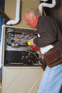 HVAC tech repairing furnace that is overheating