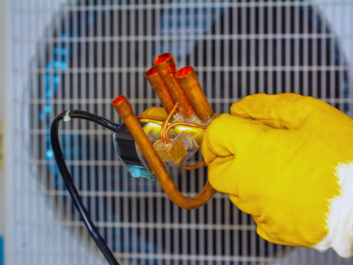 HVAC tech handling faulty reversing valve on heat pump